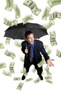 Raining money on a businessman with umbrella